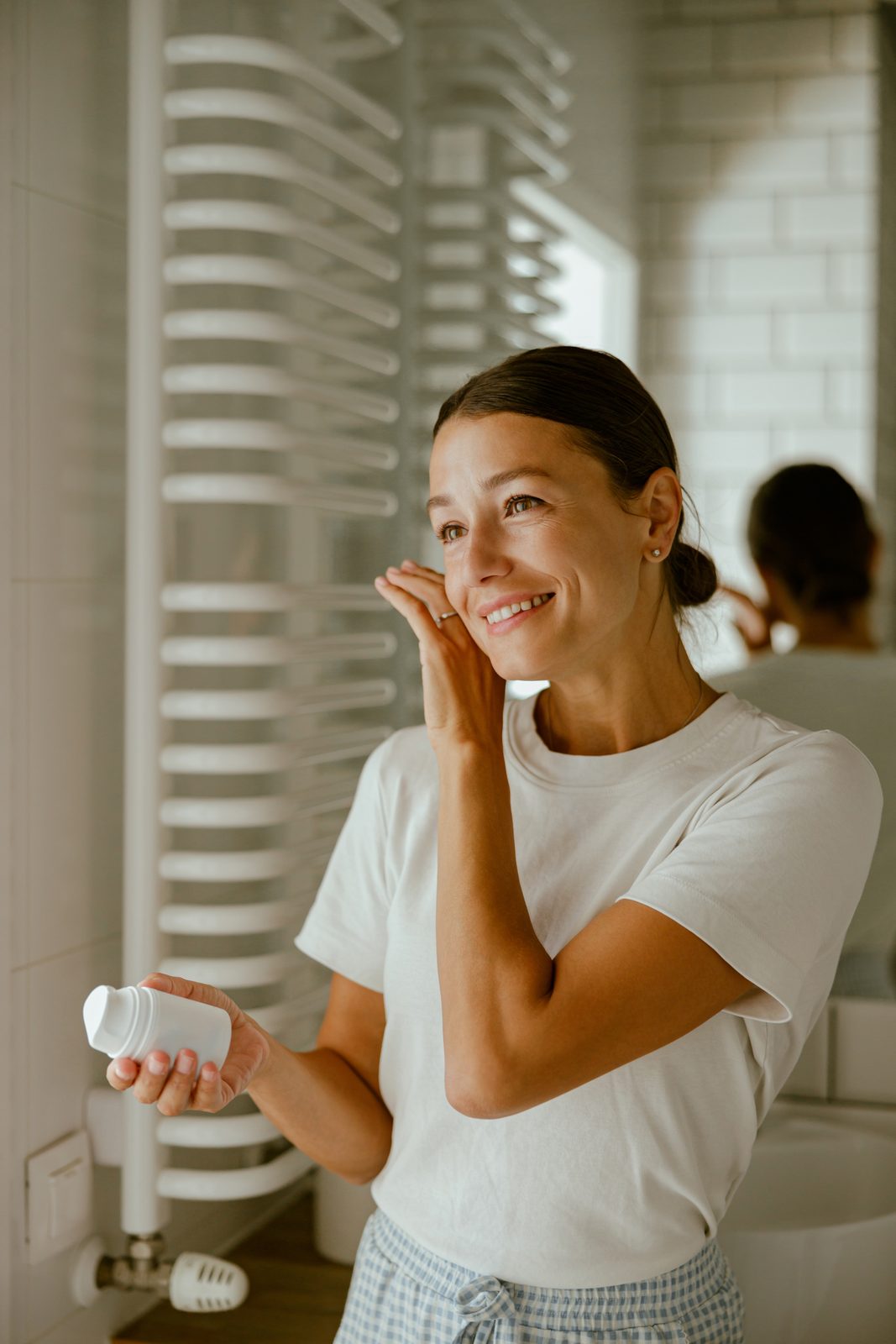 Woman enjoying her morning skincare routine in the bathroom