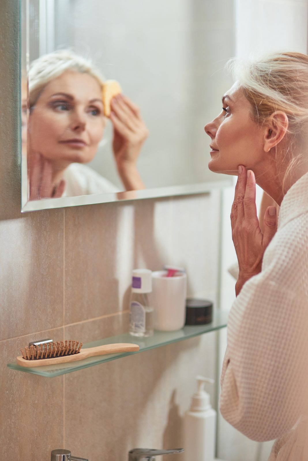 Woman doing her skincare routine in a bright bathroom