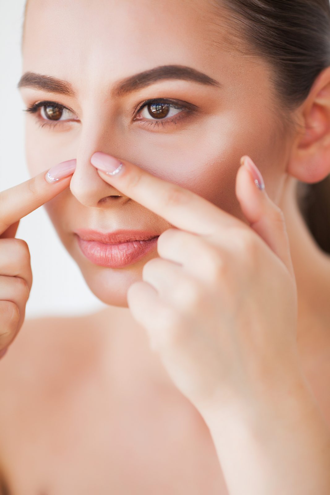 Woman pressing at a spot on her nose